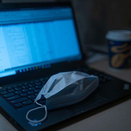Medical mask on keyboard of laptop